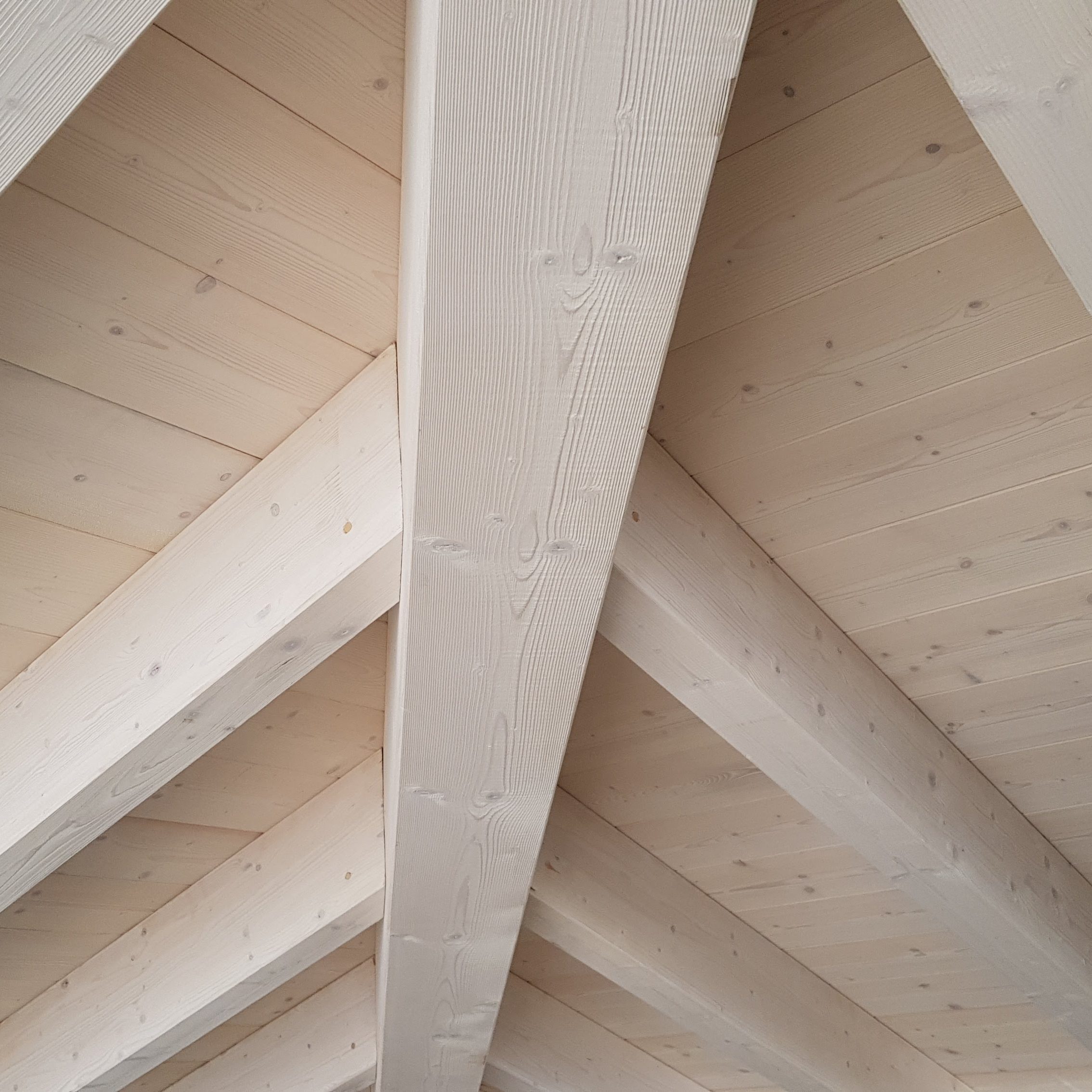una copertura in legno bianca, si vedono le assi di legno e le travi