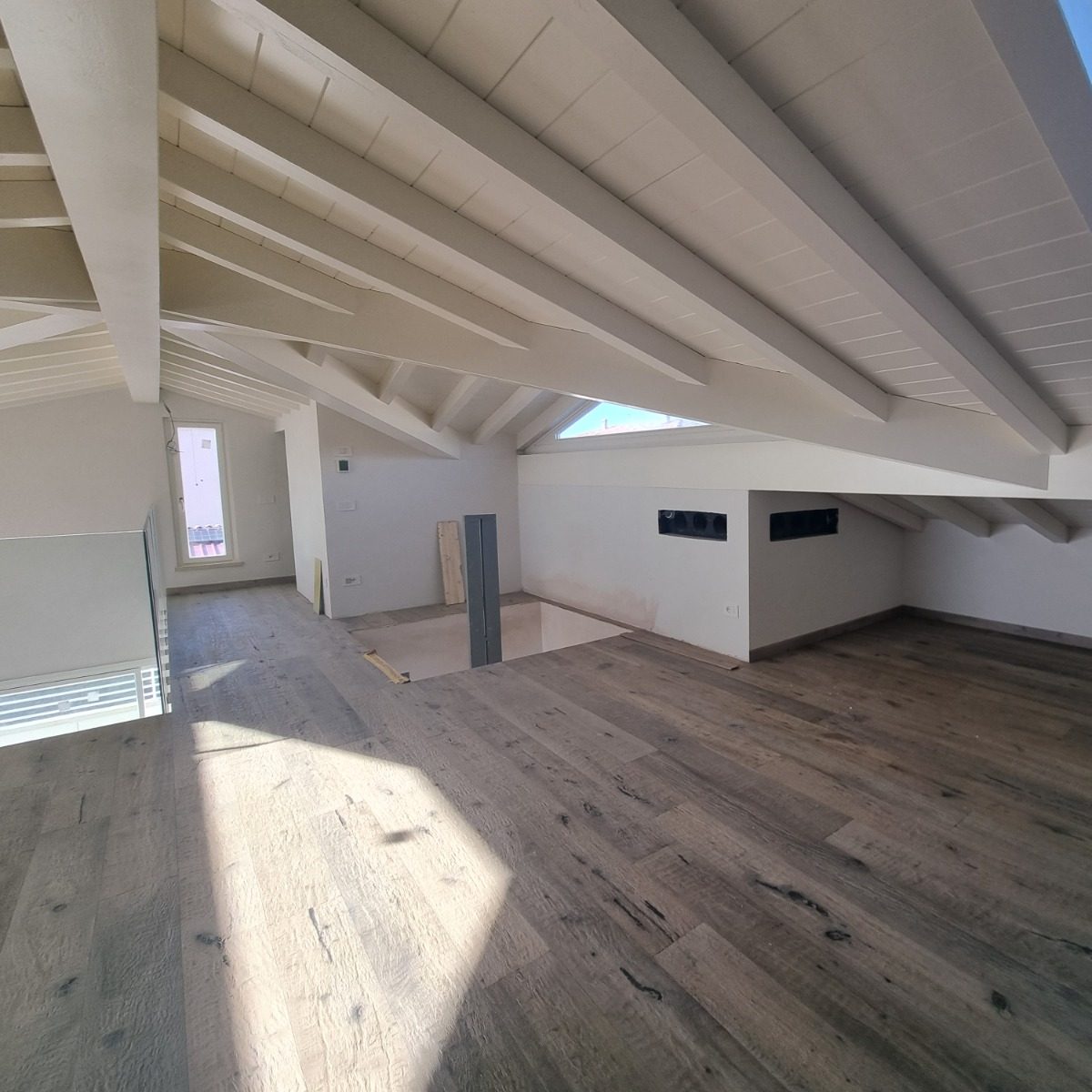 un sottotetto con una copertura in legno bianca, si vedono le assi di legno e le travi